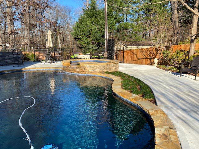 Southeastern Tree and Landscaping | beautiful backyard with pool and stone and bench