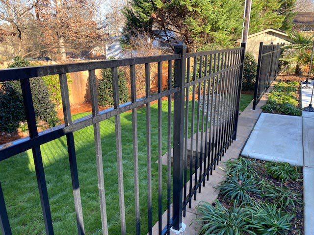 Southeastern Tree and Landscaping | beautiful backyard with iron fence and stone steps
